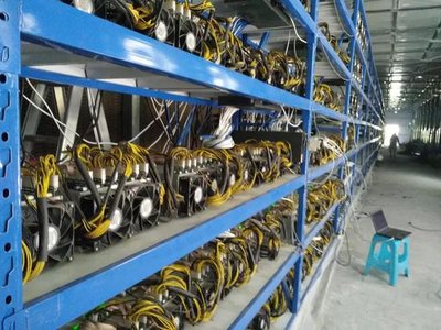 View of a large mining farm with rows of mining rigs under controlled conditions